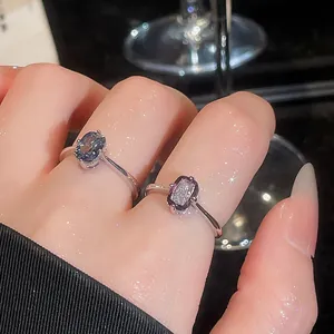 Close-up of vintage silver open rings with purple and blue gemstones shown on fingers