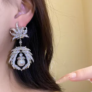 Detailed macro view of vintage maple leaf dangling earring with zircon pavé and pearl drop