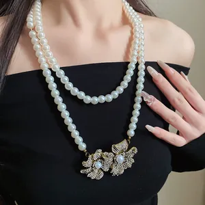 Detailed view of vintage double-layered pearl necklace with rhinestone flower pendants