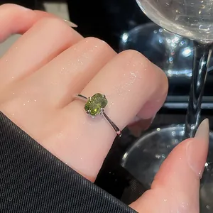 Close-up of vintage silver open ring with olive green gemstone on woman's hand