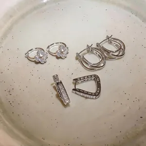 Exquisite set of silver-colored cubic zirconia earrings displayed on a ceramic dish.