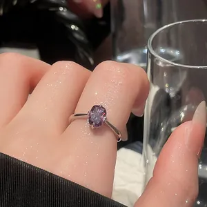 Close-up of vintage minimalist silver ring featuring a square purple crystal on finger