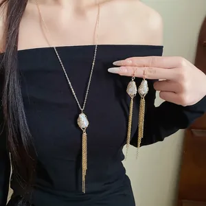 Elegant gold-tone tassel necklace and earrings set with pearl accents on model