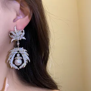 Elegant close-up view of vintage silver maple leaf earring with zircon stones and pearl drop