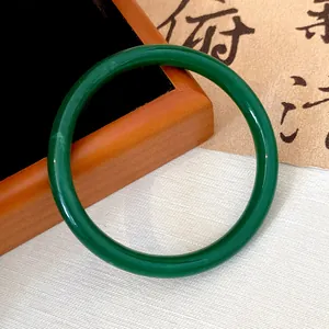 Detailed macro view of an emerald green jade-style round glass bangle for Hanfu accessories