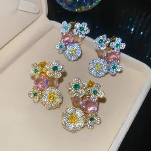 Detailed view of luxury zircon flower stud earrings with colorful gemstones in a box