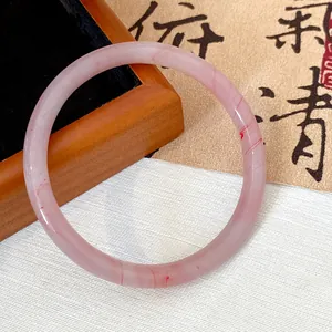Detailed close-up of a pink marbled glass bangle with elegant red textures and shine