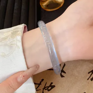 Close-up detail of a translucent light blue glass bangle with bubble texture on wrist