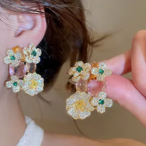 Detailed macro view of sparkling zirconia flower earrings with pink and green stones