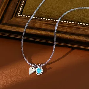 Detailed macro view of glass bead necklace featuring a vibrant blue heart zircon