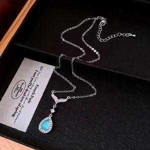 Collier pendentif queue de poisson avec zircon bleu en forme de goutte dans son coffret