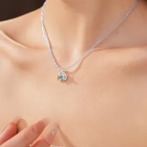 Close-up of elegant blue glass bead necklace with a heart-shaped zircon pendant