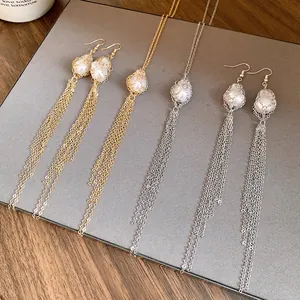 Detailed view of baroque pearl earrings and necklaces with long metal tassels
