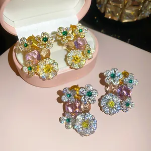 Close-up of floral stud earrings featuring pink, yellow, and green cubic zirconia