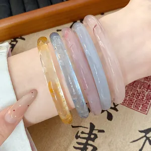 Set of colorful translucent resin bangles in traditional Ding Dang style on wrist