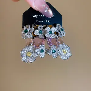 Close-up of sparkling floral earrings with multi-color cubic zirconia and pink gems