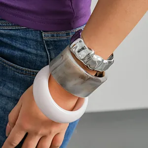 Primo piano di bracciali in acrilico e bracciale a polsino pieghettato argento