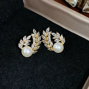 Close-up of elegant 18k gold plated wheat ear earrings with pearls and crystals