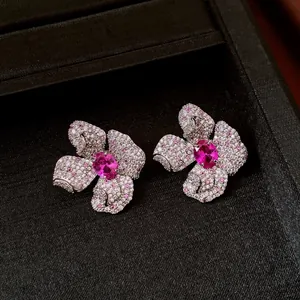 Dettaglio macro di eleganti orecchini floreali con pietre centrali in zircone rosa brillante