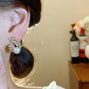 Elegant 18k gold plated wheat ear pearl stud earrings worn by a model in a close-up