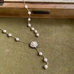 Elegante Perlenkette mit einem glitzernden Zirkonia-Kamelienanhänger in edler Silberoptik.