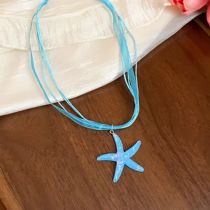 Close-up of a blue resin starfish pendant necklace with multi-strand ribbon cords
