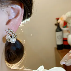 Detailed close-up of 18k gold-plated wheat ear earring with pearl and crystals