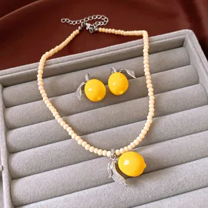 Close-up of vintage lemon jewelry set with resin charms and zircon-encrusted leaves