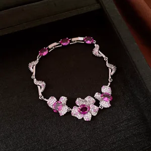 Splendido bracciale argentato con fiori in zircone rosa su sfondo scuro elegante