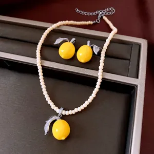 Detail of lemon pendant jewelry set with beaded necklace and crystal leaves