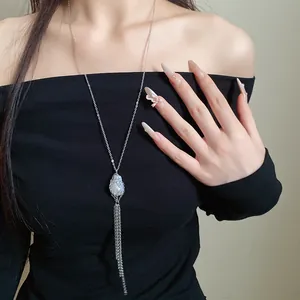 Close-up of a vintage long pearl tassel necklace on a model wearing a black dress
