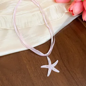 Close-up detail of the iridescent lavender resin starfish pendant with pink cord