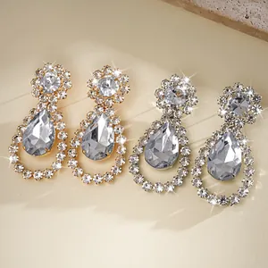 Dettaglio di orecchini a goccia con strass incastonati in oro e argento