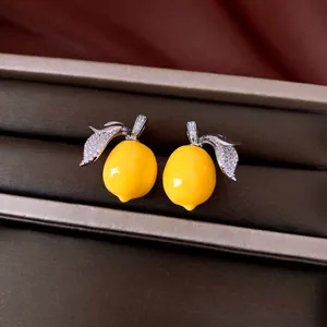 Close-up view of yellow resin lemon jewelry set featuring zircon-encrusted silver leaves