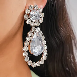 Dettaglio ravvicinato di orecchini a goccia in argento con strass scintillanti.