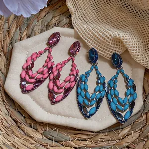 Elegant rhinestone hollow earrings in pink and blue colors on display.