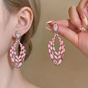 Elegant pink enamel statement earrings with sparkling rhinestone accents in hollow design.