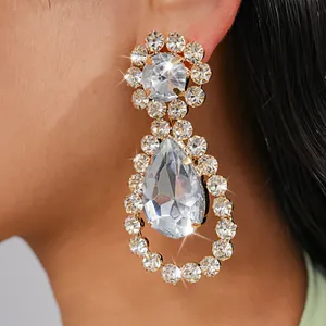 Dettaglio ravvicinato di orecchini a goccia di lusso con strass sull'orecchio della modella