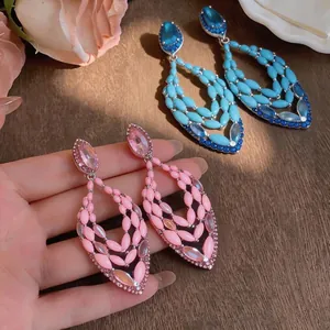 Elegant bohemian style openwork drop earrings featuring sparkling pink and turquoise rhinestones.