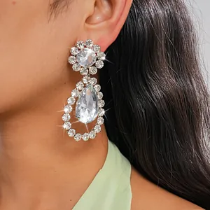 Primo piano dettagliato di eleganti orecchini con strass a forma di goccia su modella