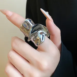 Vista dettagliata di un anello geometrico contorto argento irregolare su un dito