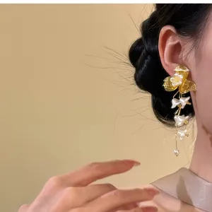 Detail shot of elegant French vintage gold flower tassel earrings worn on an Asian model
