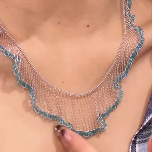 Close-up detail of a silver French lace fringe necklace with blue beads