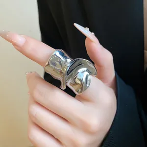 Primo piano di un anello geometrico argento con trama in metallo liquido