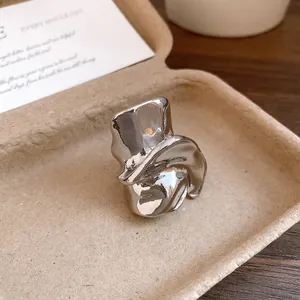Vista dettagliata di un anello geometrico scultoreo irregolare in argento fuso in vassoio