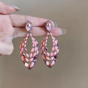 Detailed macro view of pink drip oil hollow earrings with shimmering purple rhinestones