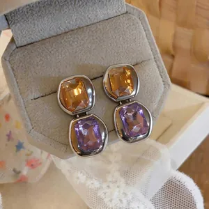 French vintage square crystal earrings with silver needles on a beige box