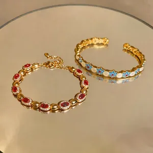 Elegante set di bracciali vintage dorati con gemme rosse e fiori in smalto colorato