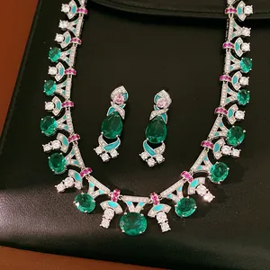 Detailed view of court-style necklace and earring set with emerald green stones