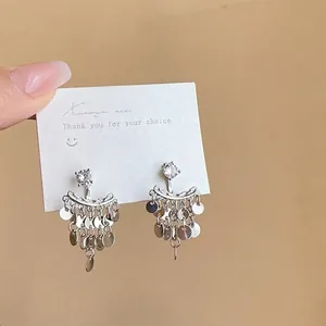 Detailed view of silver multi-layer sequin tassel earrings with brilliant stone studs